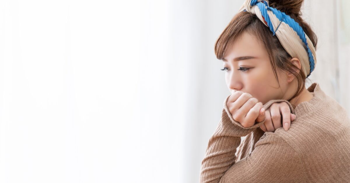 手を口元に当てて悩む女性の不安やストレスのイメージ