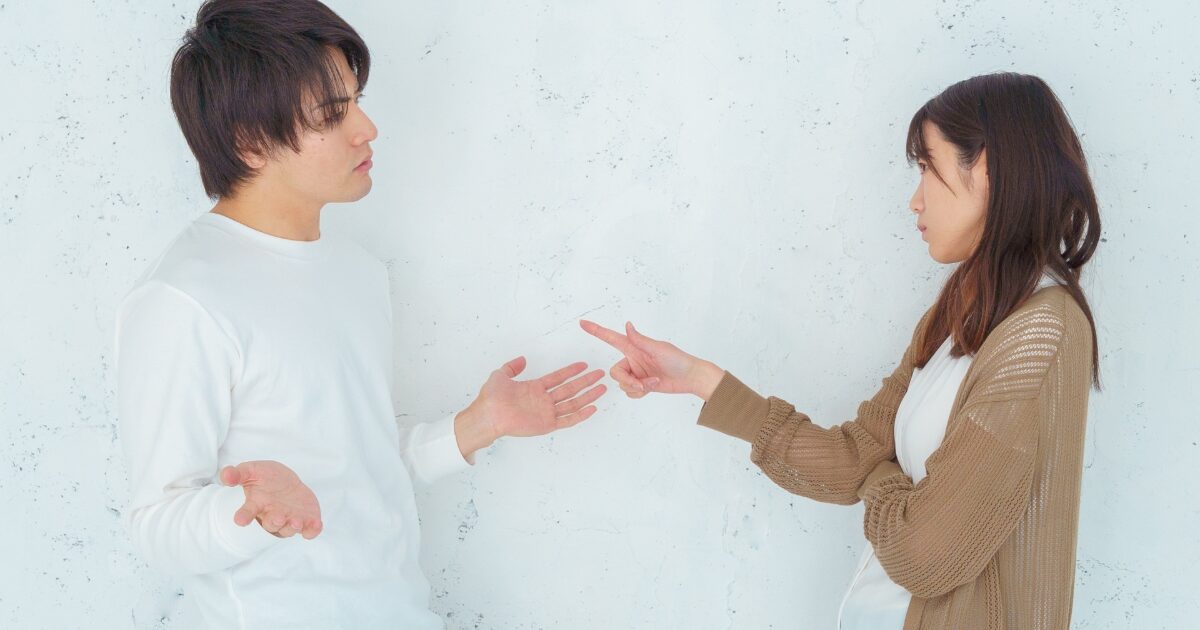 口論する男女が向かい合い指差しで言い争う様子