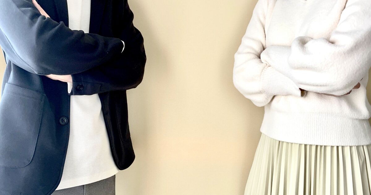 腕を組んで距離を取る男女の険悪な関係イメージ
