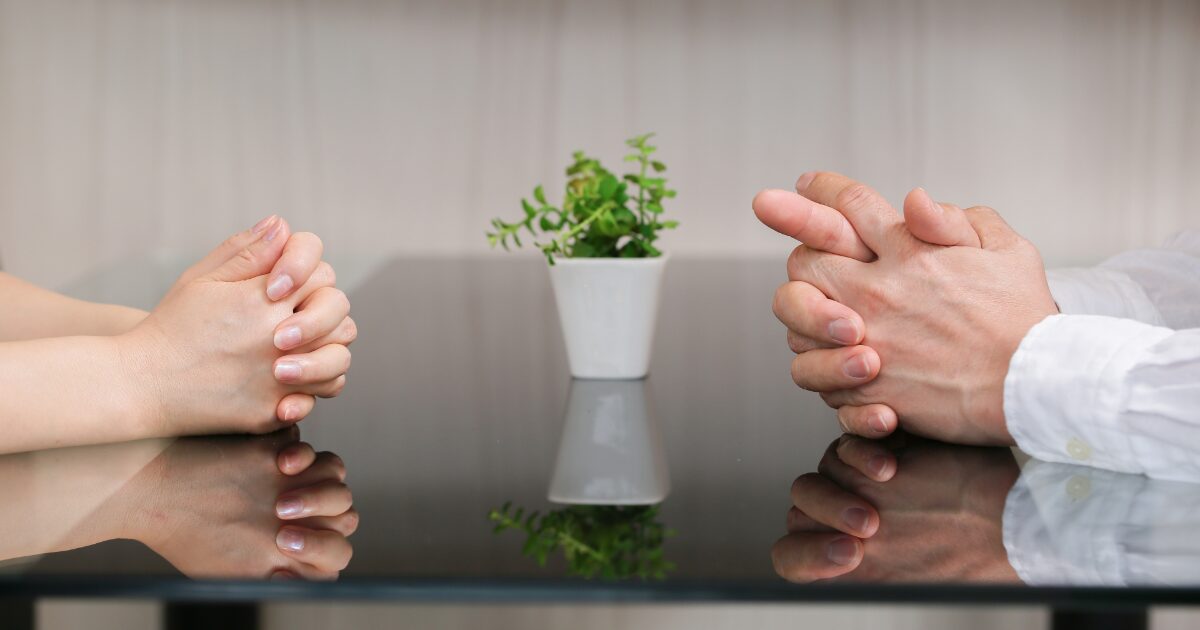 向かい合い手を組んで会話する男女の真剣な話し合い